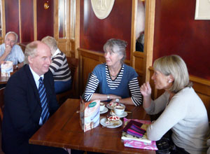 Malcolm sitting at a table with two women coffee drinkers